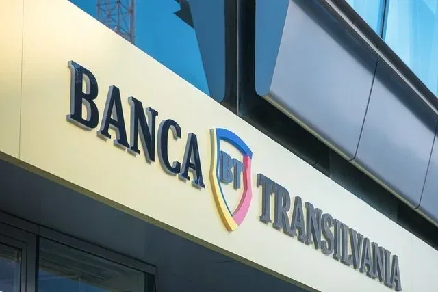 Logo-ul Băncii Transilvania pe fațada clădirii sale moderne.