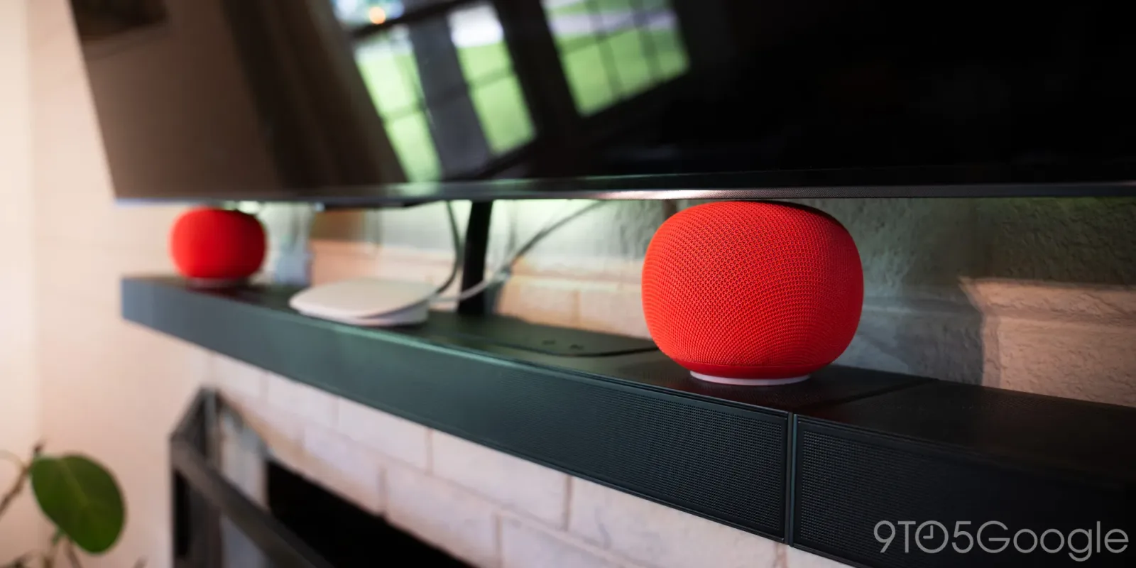 Difuzoare Google Home pe un suport, conectate la un televizor.