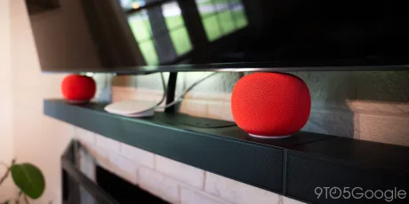 Difuzoare Google Home pe un suport, conectate la un televizor.