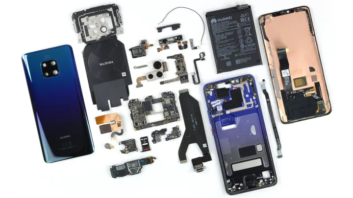 Telefoane demontate și componente electronice dispersate pe o masă.