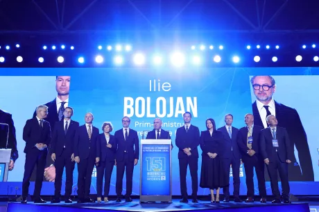 Ilie Bolojan și echipa sa pe scena unui congres PNL, sub lumini strălucitoare.