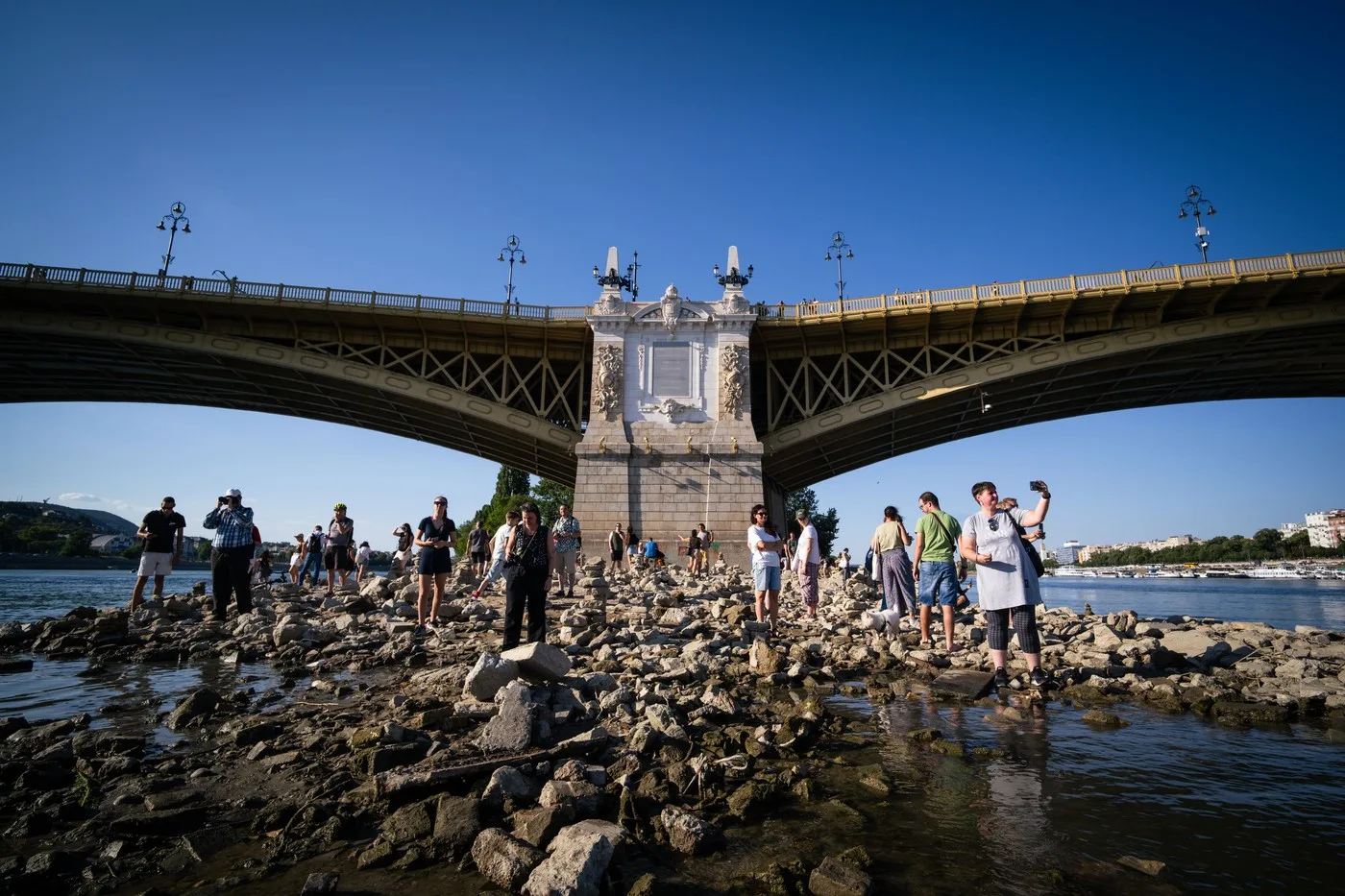 Persoane pe malul Dunării, admirând nivelul scăzut al apei la Budapesta.