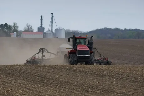 Tractor lucrând pe un câmp agricol în timpul primăverii.