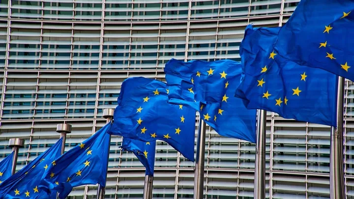 Steaguri ale Uniunii Europene fluturând în fața clădirii Comisiei Europene.