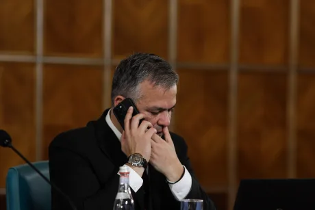 Un politician discutând la telefon în timpul unei ședințe importante.