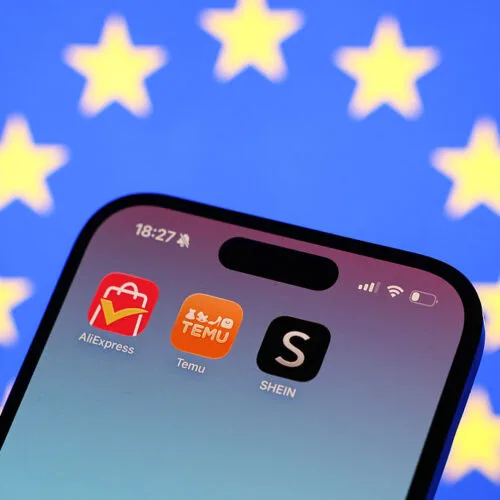Logo-urile aplicațiilor AliExpress, Temu și SHEIN pe un telefon mobil.