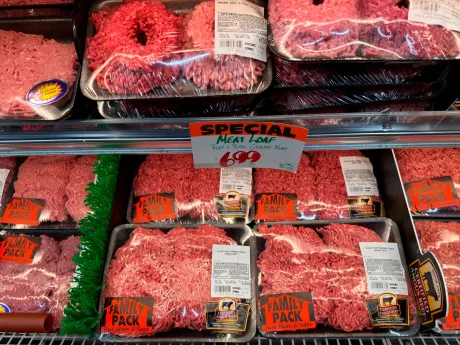 Carne tocată de vită expusă într-un magazin, cu etichete de preț vizibile.