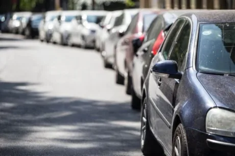 Mașini parcate pe o stradă din România, evidențiind problema importului de autoturisme.