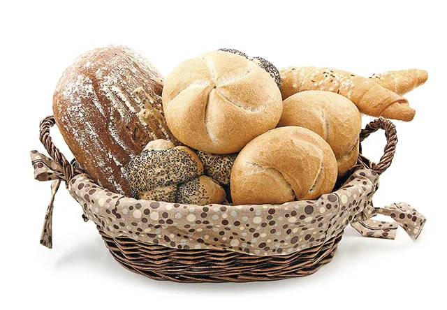 Coș cu pâine proaspătă și produse de panificație variate.