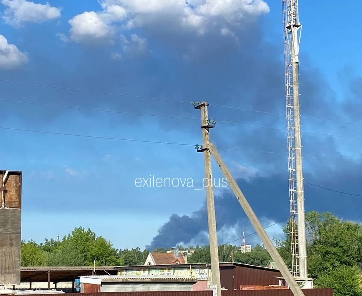 Fum gros se ridică deasupra unei zone industriale afectate de un incendiu.