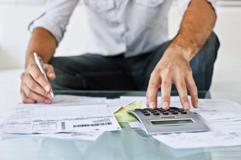 Persoană care analizează documente financiare și calculează datorii.
