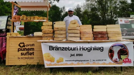Stand cu brânzeturi artizanale la târg, cu produse variate și un producător zâmbitor.