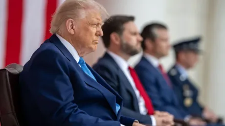 Donald Trump ascultând discursuri în fața unui public atent.