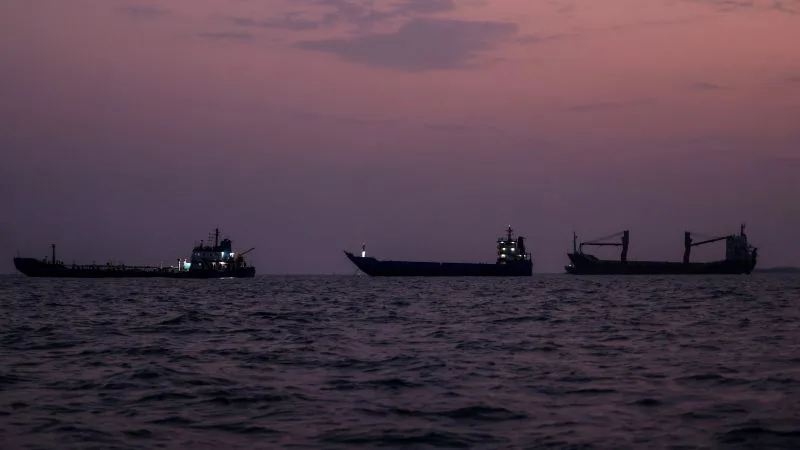 Vasuri comerciale navigând în apele Strâmtorii Hormuz la apus.