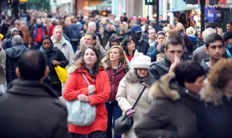O mulțime de oameni pe o stradă aglomerată într-un oraș.