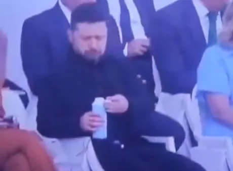 Volodimir Zelenski deschide o sticlă de apă la parada din Franța.
