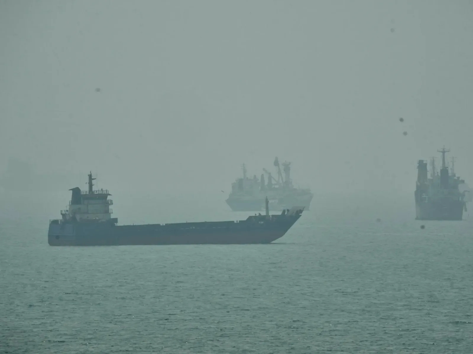 Vapor pe apă în condiții de ceață, simbolizând tensiuni maritime.