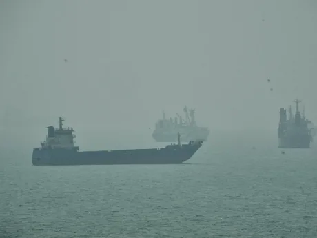 Vapor pe apă în condiții de ceață, simbolizând tensiuni maritime.