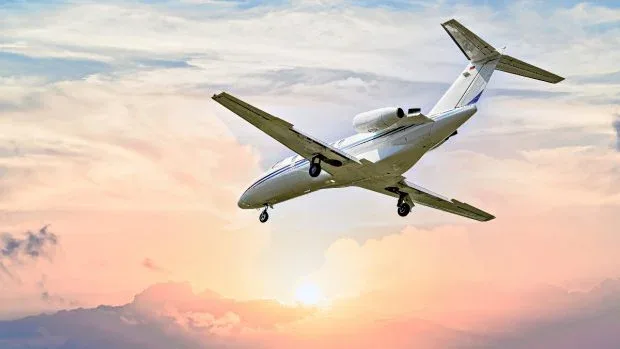 Avion în zbor pe un fundal de apus spectaculos.