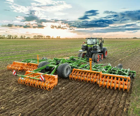 Tractor pe câmp, pregătind terenul pentru culturi agricole.