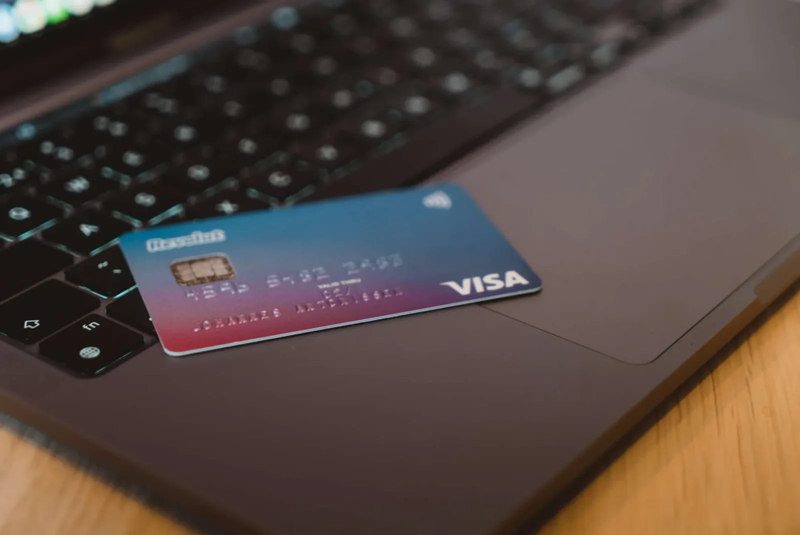 Card Revolut pe un laptop, simbolizând plățile digitale.