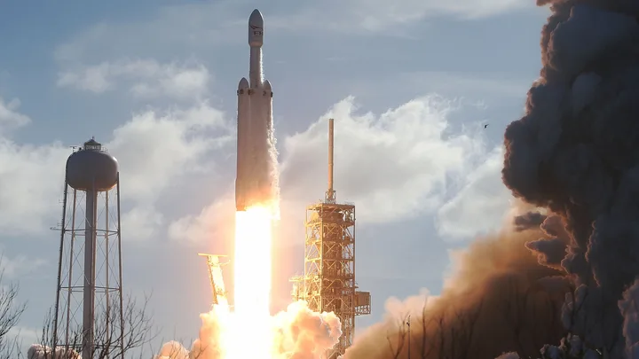 Lansare SpaceX Falcon 9 cu fum și flăcări în fundal.