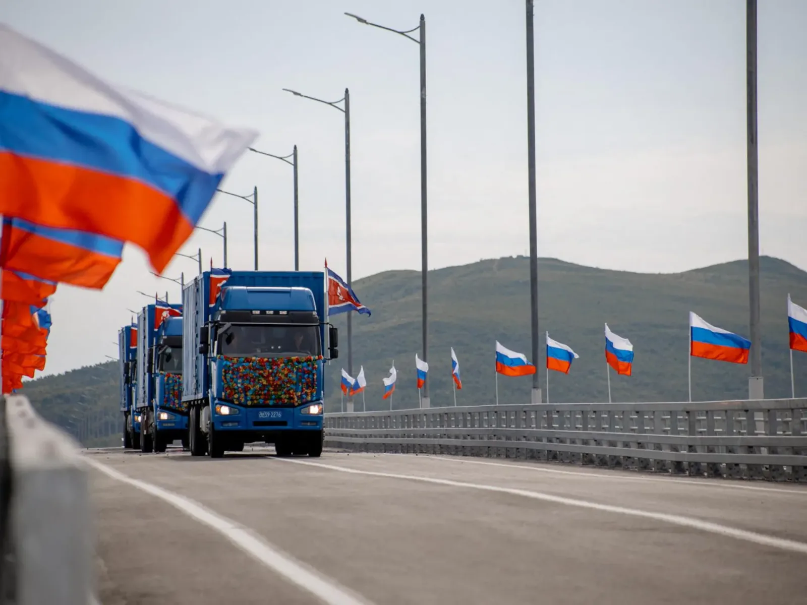 Camioane trec pe noul pod rutier între Rusia și Coreea de Nord.