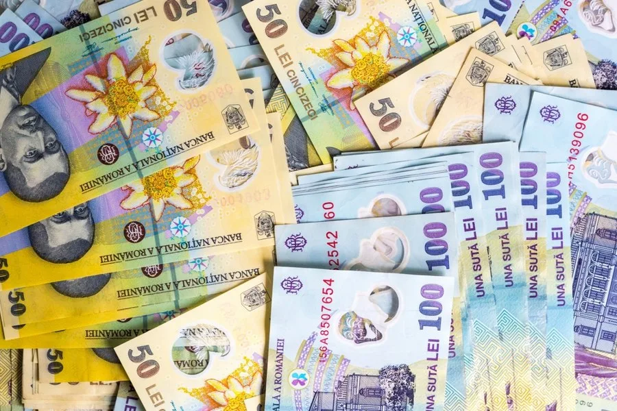 Bancnote românești de diverse valori aranjate pe o suprafață plană.