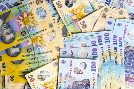 Bancnote românești de diverse valori aranjate pe o suprafață plană.