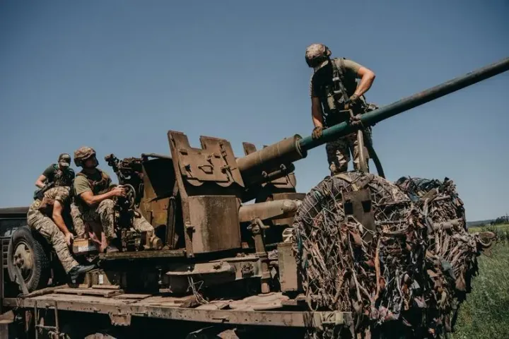 Soldați ucraineni pregătesc echipamente militare pe teren.