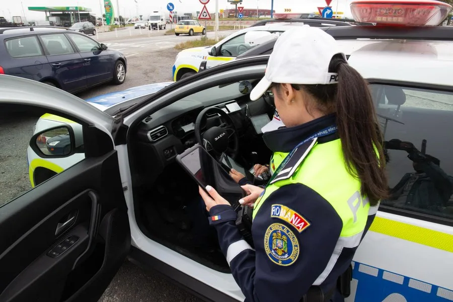 Polițist verificând datele în timpul unei opriri rutiere.