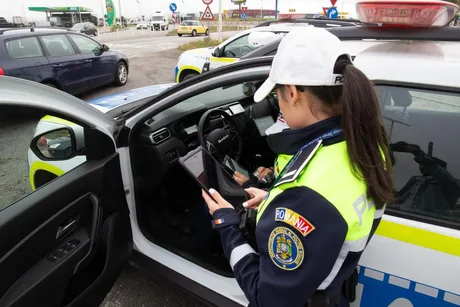 Polițist verificând datele în timpul unei opriri rutiere.