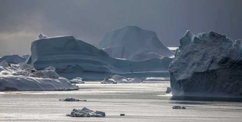 Peisaj glaciar din Groenlanda, cu banchize și ape liniștite.