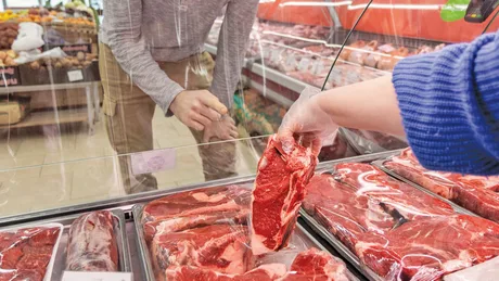 Client alegând carne proaspătă dintr-un supermarket din Ungaria.