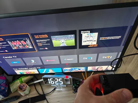 Echipament TV conectat la un televizor modern, cu interfața de programe deschisă.
