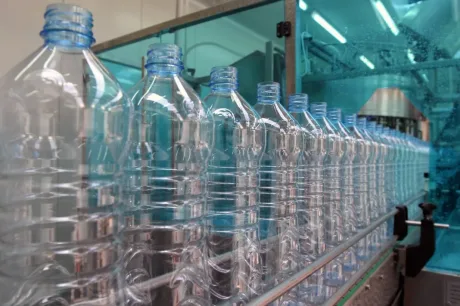 Sticle de apă minerală pregătite pentru îmbuteliere într-o fabrică modernă.