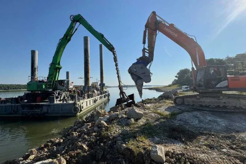 Excavatoare în acțiune pe brațul Dunărea Veche pentru dragaj.