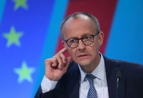 Cancelarul Friedrich Merz în timpul unei conferințe de presă, cu steagul Uniunii Europene în fundal.