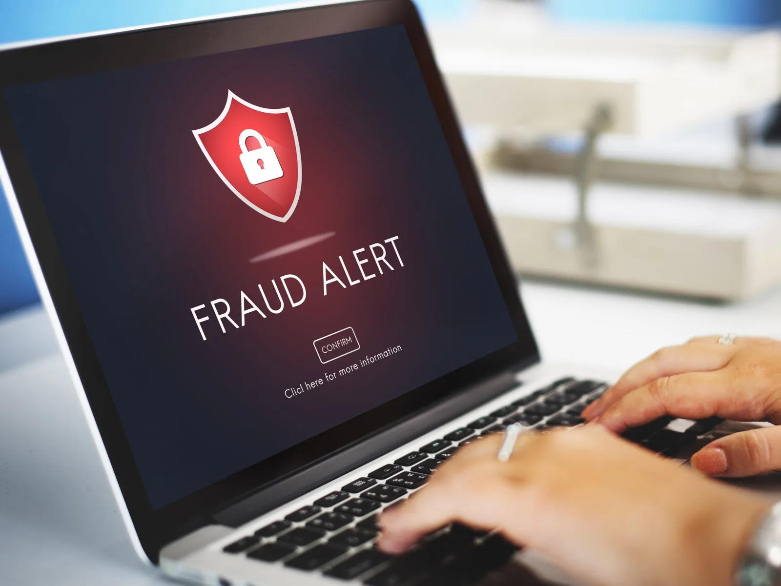 Laptop cu mesaj de alertă pentru fraudă pe ecran.