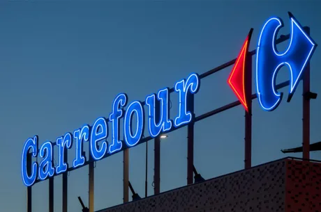 Logo-ul Carrefour iluminat pe timp de noapte, evidențiind brandul.
