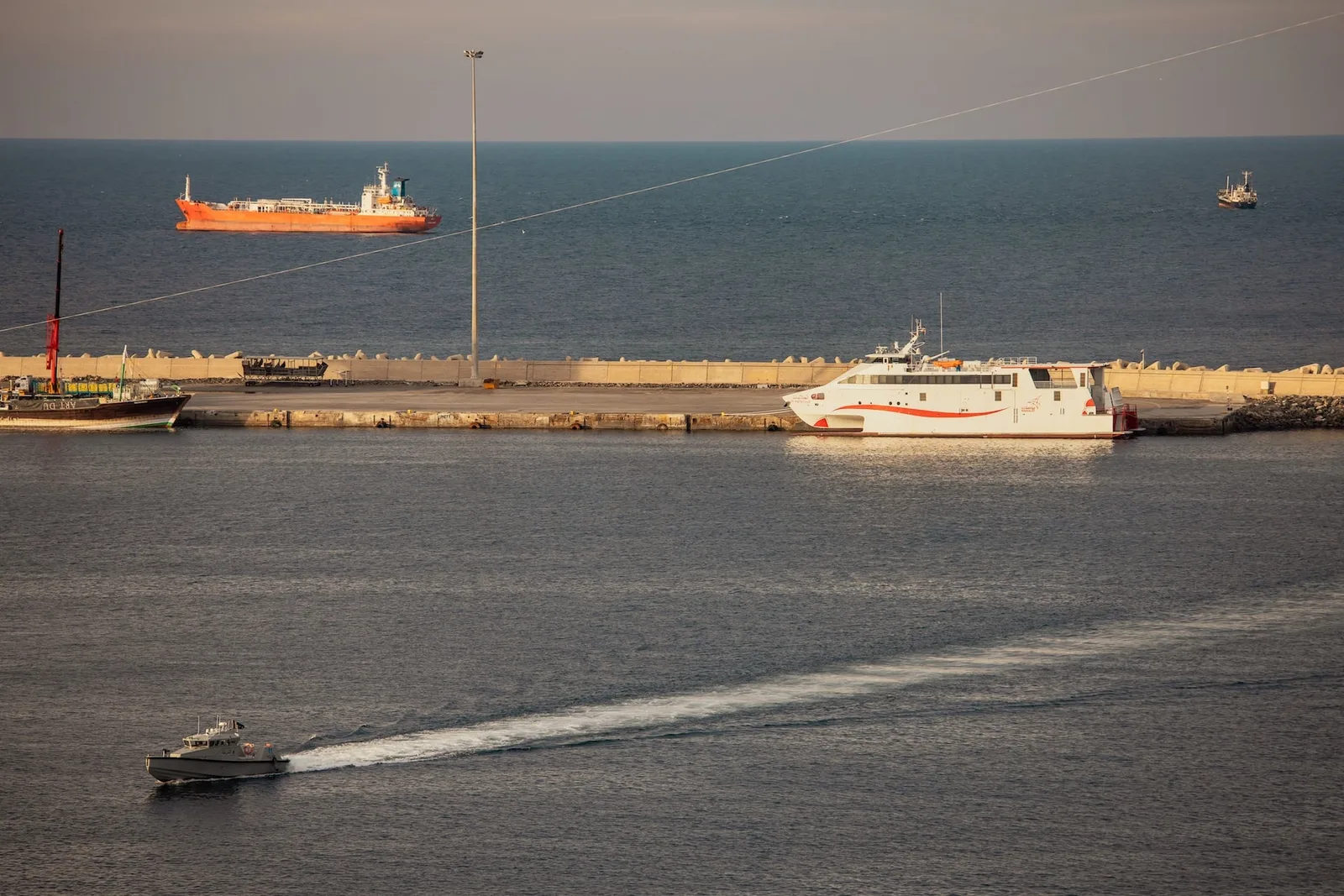 Nave comerciale ancorate în Strâmtoarea Hormuz, cu activitate maritimă intensă.