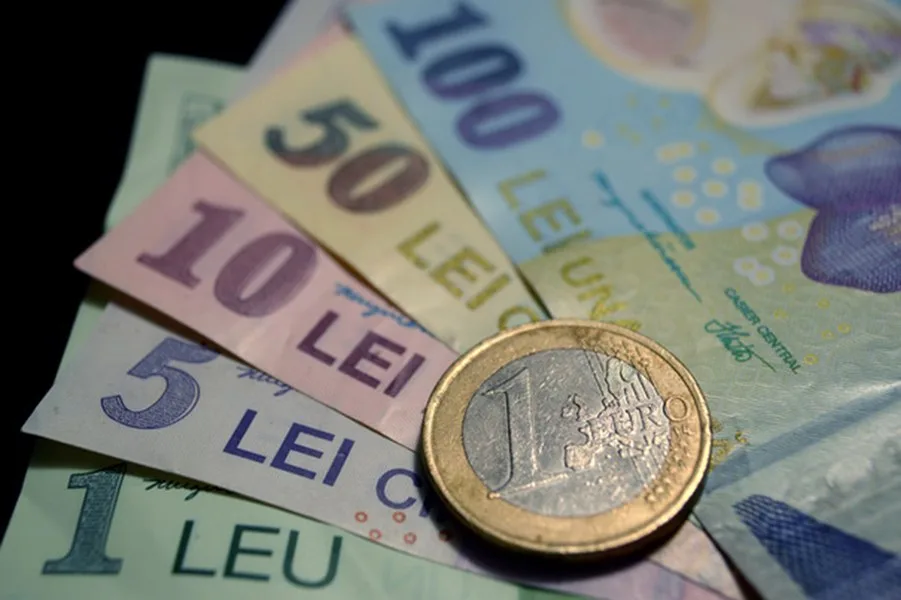 Bancnote românești și o monedă euro pe un fundal neutru.