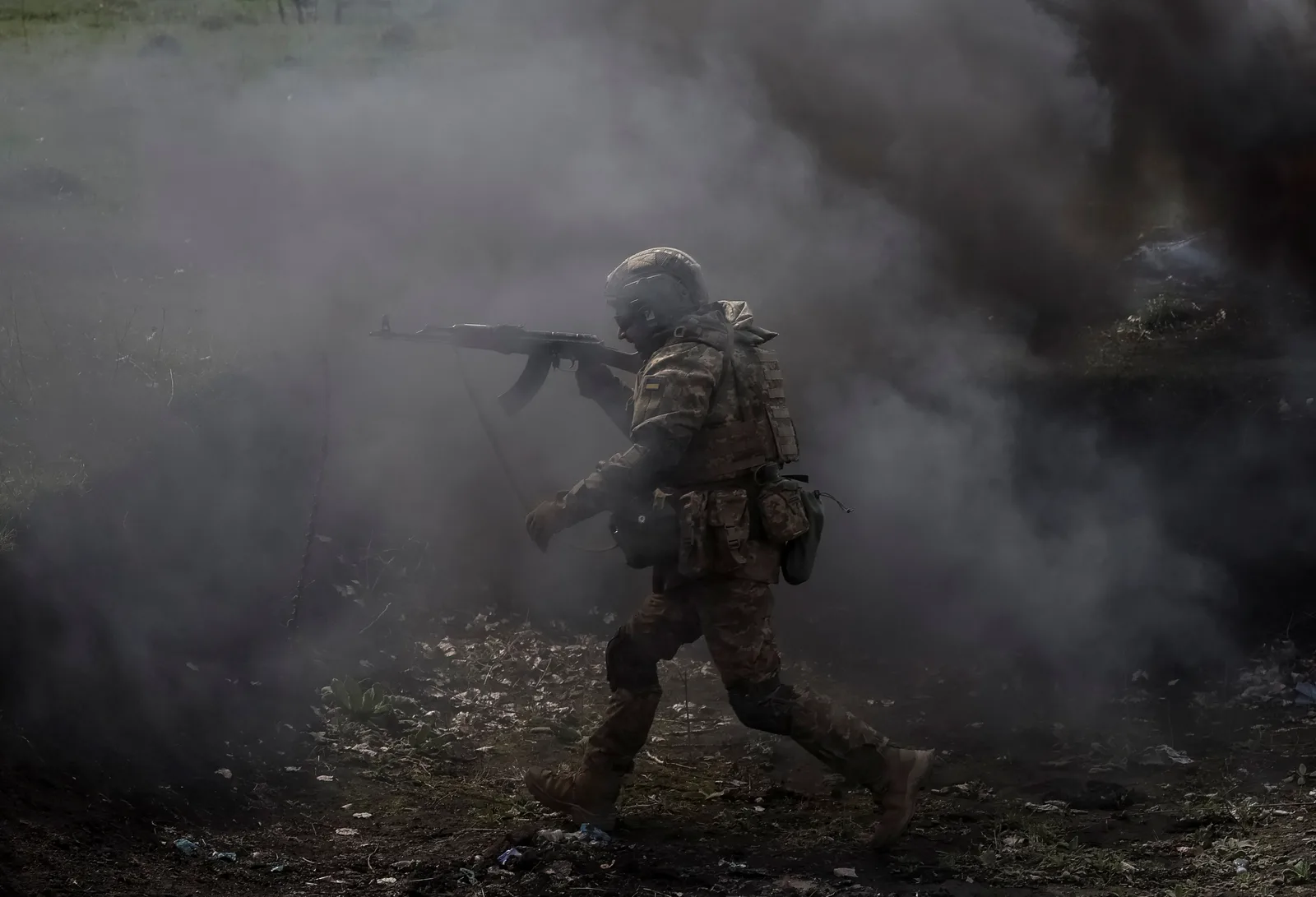 Soldat în acțiune, înconjurat de fum și incertitudine.