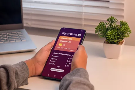 Persoană utilizând un portofel digital pe telefonul mobil, cu detalii despre tranzacții.