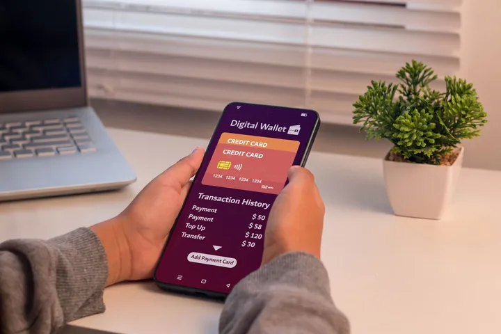 Persoană utilizând un portofel digital pe telefonul mobil, cu detalii despre tranzacții.