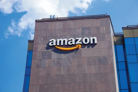 Logo-ul Amazon pe o clădire modernă, sub un cer senin.