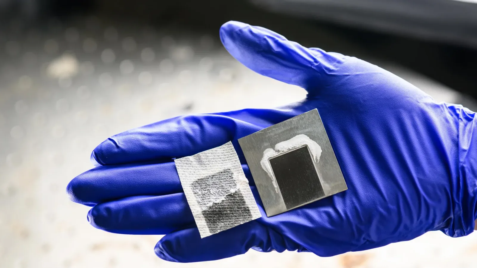Sistem de desalinizare solară cu panouri din metal negru, prezentat pe o mână.