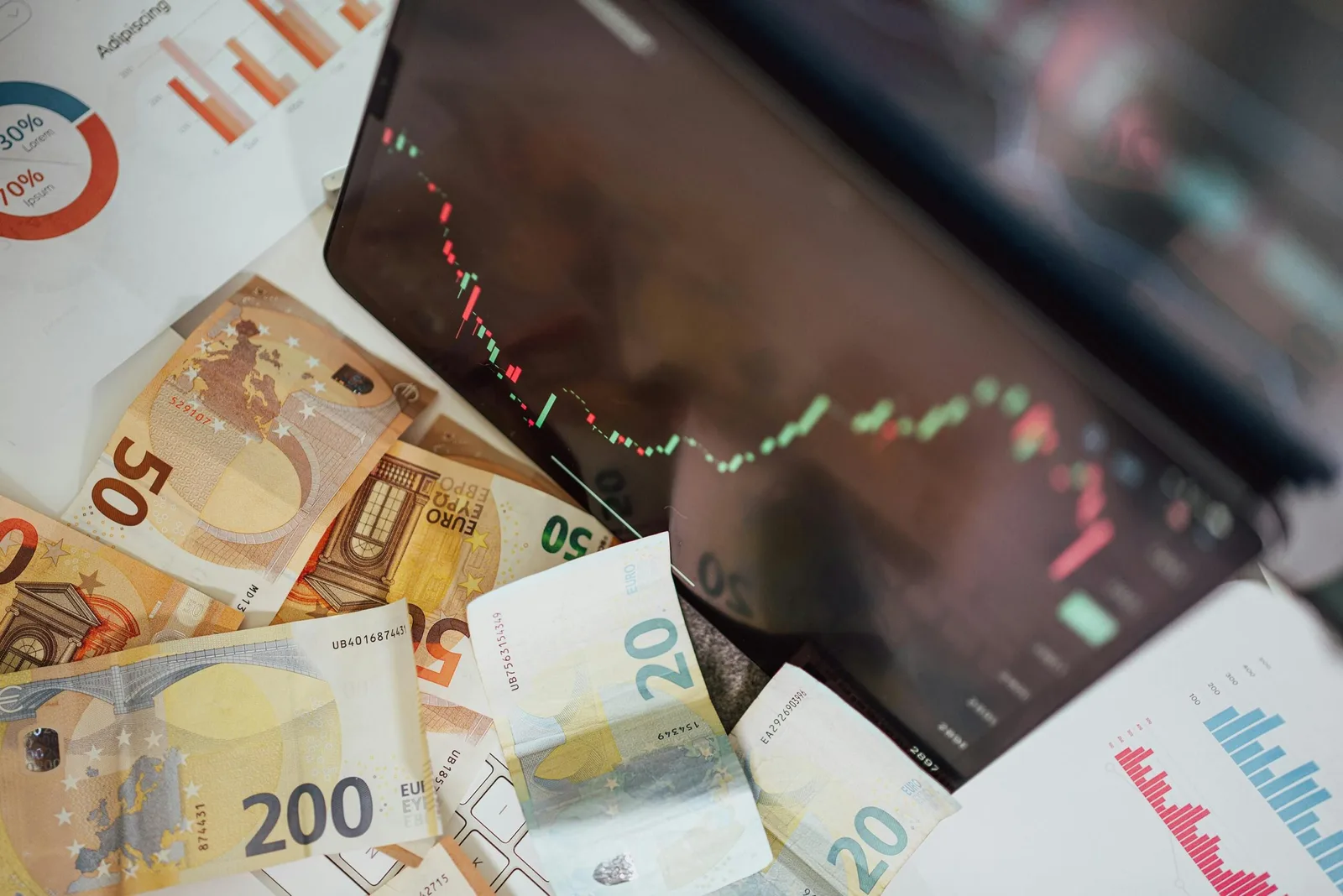 Grafic economic și bancnote pe un birou, evidențiind recesiunea.