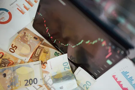 Grafic economic și bancnote pe un birou, evidențiind recesiunea.