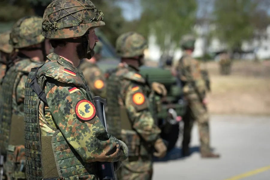 Soldați germani în uniformă, pregătiți pentru exerciții militare.